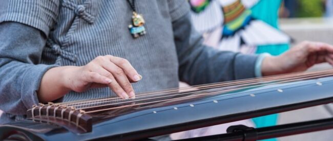 Musiker spelar på en traditionell stränginstrumentliknande nyckelharpa